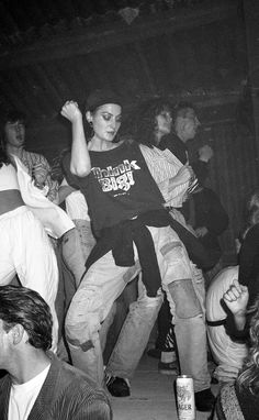 a group of people dancing in a dark room with one person on his back and the other