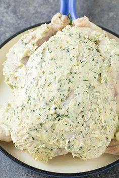 a white plate topped with chicken covered in cheese and herbs next to a blue toothbrush