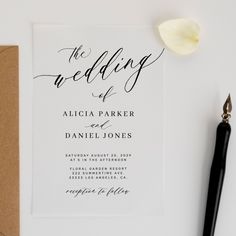 the wedding stationery is laid out next to a pen and paper