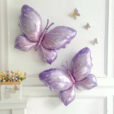 two purple butterflies are hanging on the wall