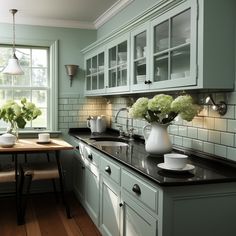 a kitchen with green cabinets and black counter tops, white vases on the sink