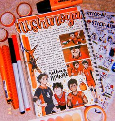 an orange and white notebook with stickers on it next to markers, pens and scissors