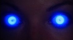 two blue eyes are glowing in the dark