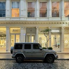 a silver jeep parked in front of a building