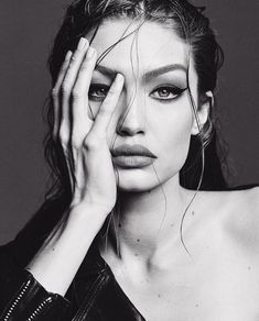 a black and white photo of a woman with her hands on her face