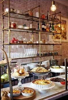 a buffet with lots of food and drinks on the shelves in front of it's windows