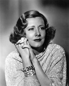 an old black and white photo of a woman with her hands on her chins