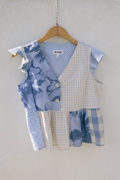 a blue and white shirt hanging on a wall next to a hanger with clothes