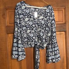 Blue Floral Print. Sleeves Are Flared At Cuff V Neck. Tie At Bottom Front Never Worn. Nwt Blue Bell Sleeve Summer Tops, Blue Bell Sleeve Tops For Summer, Blue Bell Sleeve Top For Fall, Aztec Shirt, Cutout Blouse, American Eagle Shirt, Boho Crop Tops, Off Shoulder Shirt, Blue Floral Blouse