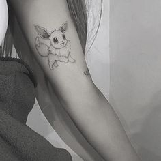 a woman's arm with a small tattoo of a pikachu on it