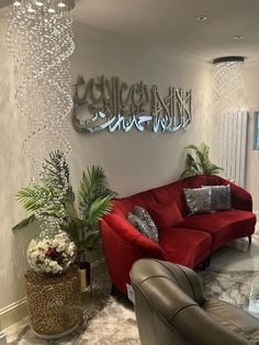 a living room with red couches and chandelier hanging from the ceiling above