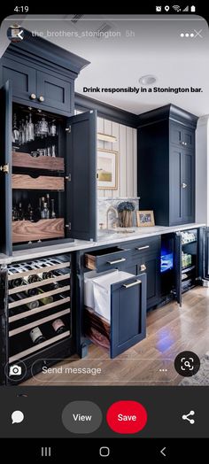 a kitchen with dark blue cabinets and wine racks in the center, along with white walls