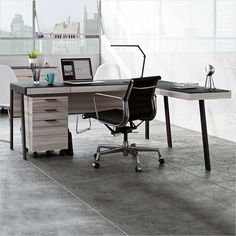 an office desk with two chairs and a laptop on it, in front of a large window