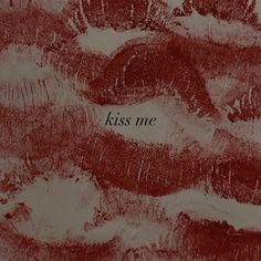 the words kiss me are written in brown ink