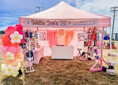 a pink and white tent with balloons on it