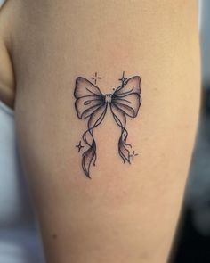 a woman's thigh with a bow tattoo on it