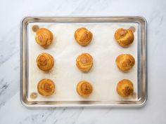 twelve small pastries on a baking sheet ready to be baked in the oven,