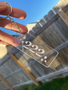 a hand holding a keychain that has the number twenty two stars on it