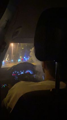 the view from inside a car at night with lights on and fog in the air