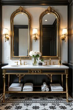 a black and gold bathroom with two large mirrors above the double sink, white towels on the floor