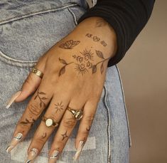 a woman's hand with tattoos on her left arm and two rings on her left wrist