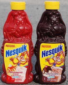 two bottles of nestle's chocolate syrup sitting on the ground next to each other