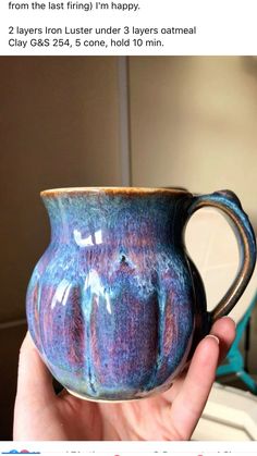 a hand holding a blue and purple mug