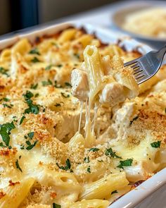 a fork is being lifted out of a casserole dish with chicken and cheese