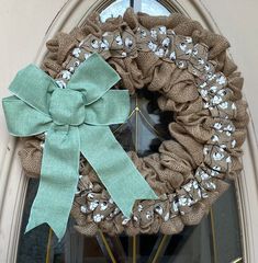 a burlock wreath with a green bow on the front door