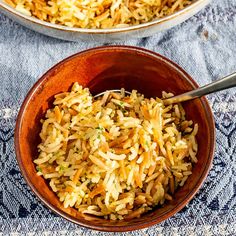 two brown bowls filled with rice on top of a blue table cloth next to each other