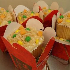 some cupcakes with candy in them are sitting on top of each other and wrapped in paper