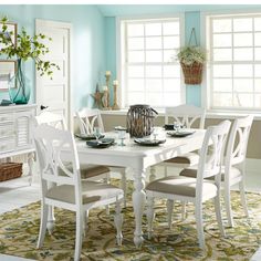 a dining room table and chairs with blue walls