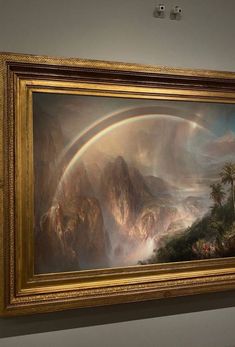 a painting on display in a museum with mountains and rainbows painted above the paintings