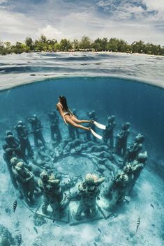 a woman is swimming in the ocean with corals