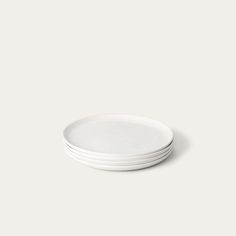 four white plates stacked on top of each other