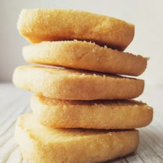 a stack of doughnuts sitting on top of a wooden table next to each other