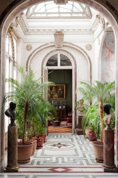 an archway leading to a sitting area with potted plants