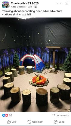 an image of a tent set up in the middle of a forest with logs around it