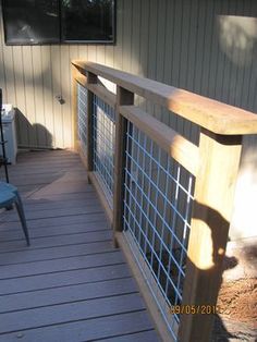 a wooden deck with blue chairs on it and a fence around the back yard area