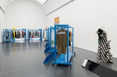 a room filled with lots of different types of clothing on display in front of a white wall