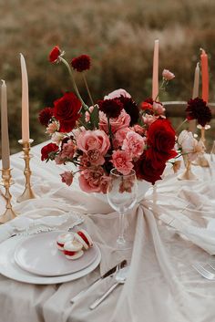 the table is set with flowers and candles