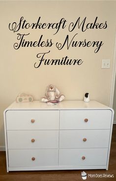 a white dresser sitting in front of a wall with writing on the top and bottom