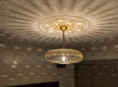 a chandelier hanging from the ceiling in a room with an intricate design on it