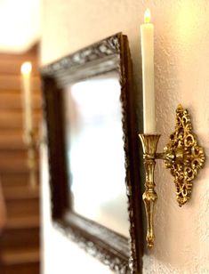 a candle that is on the wall next to a mirror