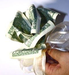 a person's hand holding money wrapped in plastic