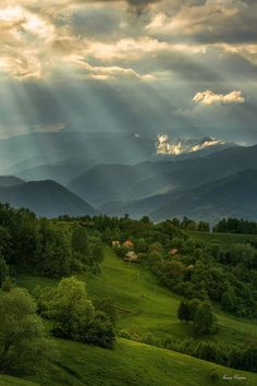 the sun shines through the clouds over mountains and valleys in this scenic landscape photo