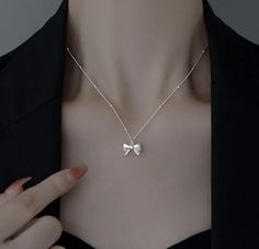 Add a touch of sophistication and charm to any outfit with this stunning Silver Bow Pendant Necklace. Crafted with meticulous attention to detail, this necklace features a delicate bow pendant that exudes timeless elegance. Features: - Material: High-quality sterling silver - Design: Intricately designed bow pendant for a classic and feminine look - Chain Length: Adjustable chain for a perfect fit, ranging from 16 to 18 inches - Clasp: Secure lobster clasp for easy wear and removal Highlights: - Versatile Style: Perfect for everyday wear or special occasions - Elegant Finish: Polished silver finish that shines beautifully - Gift-Ready: Ideal gift for birthdays, anniversaries, or any special occasion Care Instructions: - Store in a cool, dry place when not in use - Avoid contact with water Elegant Bow Pendant Necklace, Elegant Bow Necklace For Gift, Elegant Bow Necklace For Anniversary, Silver Bow Jewelry As A Gift, Silver Bow Jewelry For Gift, White Bow Tie Jewelry As Gift, White Bow Tie Jewelry For Gift, Minimalist Silver Jewelry With Bow, Classic Silver Jewelry With Bow