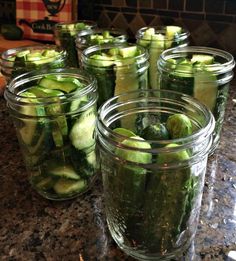 several jars filled with pickles sitting on top of a counter