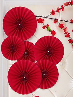 four red paper fans sitting on top of a table