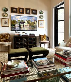 a living room filled with lots of furniture and pictures on the wall above it's glass top coffee table